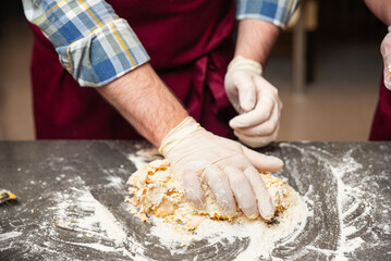 Kneading pasta dough on floured surface.