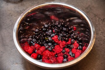 Fresh mixed berries in metal bowl.