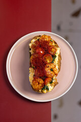Open Sandwich with Scrambled Eggs, Shrimp and Chili Threads.
Gourmet toast topped with scrambled eggs, sautéed shrimp, spinach and red chili threads, served on a pastel plate.