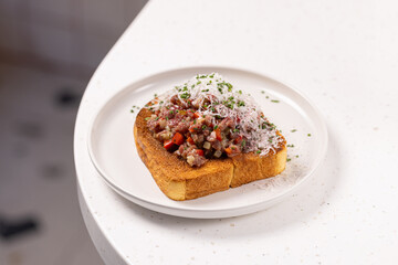 Beef Tartare Toast with Pickled Onions and Chives.
Open-faced sandwich topped with finely chopped beef tartare, pickled red onion and fresh chives on toasted bread.