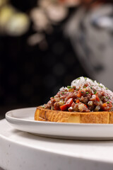 Beef Tartare Toast with Pickled Onions and Chives.
Open-faced sandwich topped with finely chopped beef tartare, pickled red onion and fresh chives on toasted bread.