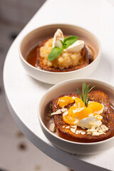 
French Toast Dessert Duo.
Two variations of French toast: one with apple compote and cream, the other with caramel, mandarins and ice cream, both served in stylish bowls.