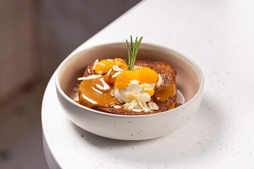 Brioche Toast with Caramel, Ice Cream and Mandarin.
Warm brioche topped with creamy ice cream, caramel sauce, mandarin slices, almond flakes and a rosemary sprig.