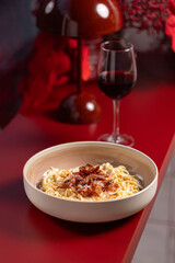 Spaghetti Carbonara with Crispy Bacon and Parmesan.
Classic Italian pasta dish with creamy sauce, crispy bacon strips and grated Parmesan, served in a modern bowl on a white surface.