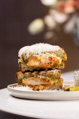 Pesto Chicken Grilled Sandwich.
Toasted sandwich with chicken, green pesto, and melted cheese, topped with shredded parmesan and served with a pickle and creamy dipping sauce.