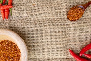 chili pepper and spices with empty space on burlap background