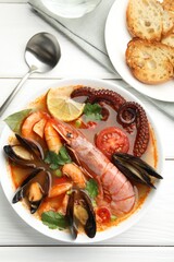 Delicious seafood soup served on white wooden table, flat lay