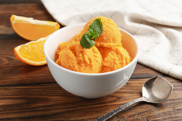 Tasty orange sorbet, fresh fruits and mint on wooden table, closeup