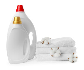 Bottles of fabric softener, cotton flowers and clean towels isolated on white
