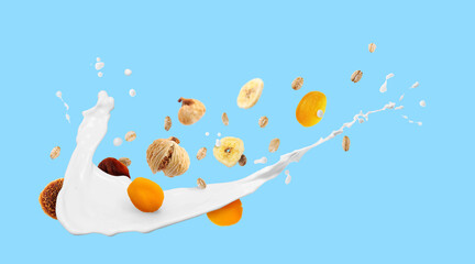 Milk splash with oat flakes and dried fruits on light blue background. Banner design