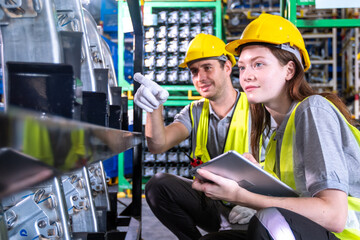 Female and male workers use tablet working in metal car part warehouse, import export, logistic business concept. Engineer checking spare part, transportation, distribution, industry factory concept.
