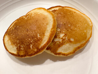 Two Pancakes , on a White Plate. 