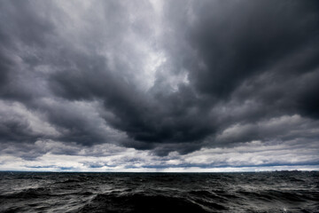 The dark sky with heavy clouds converging and a violent storm before the rain.Bad or moody weather sky and environment. carbon dioxide emissions, greenhouse effect, global warming, climate change.