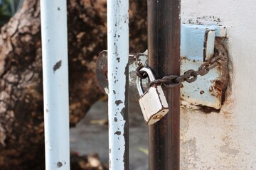 Old and rusty chain padlock on steel fence door background