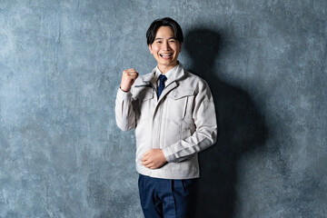 ガッツポーズをする作業服を着た男性
