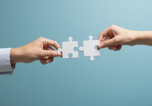 Hands connecting two white puzzle pieces on a blue background