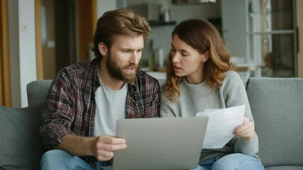 Young couple calculating domestic bills using laptop and paperwork, concerned about home finances and family budget, trying to find solutions for their financial problems - Powered by Adobe