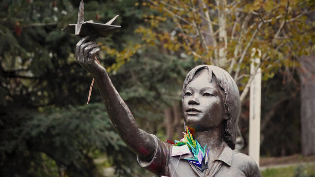 SEATTLE, WASHINGTON - APRIL 10, 2017 - Bronze statue of Sadako Sasaki holding origami paper crane, promoting peace and commemorating lives lost to nuclear war