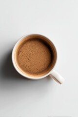 Fototapeta premium Overhead view of coffee cup, rich brown tones, minimalist presentation on white