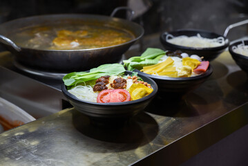 Colorful Luosifen rice noodle bowls with vegetables, tofu, and toppings at a street food stall in Old Street, Yunnan Road, Shanghai, China