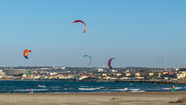 Algiers, Algeria- January 25, 2022: Kitesurf school, kitesurfing. Marina Sidi Fredj sailing club, Staoueli. Beach surfers. Sea waves. Deep blue sea, sand. Moretti city. Holyday Inn towerbuilding.