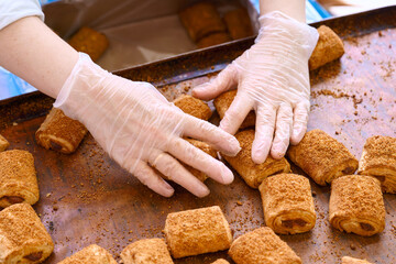 Hands carefully preparing sweet baked rolls in a cozy kitchen environment during the afternoon