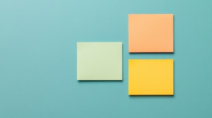 Fototapeta premium Three colorful sticky notes are arranged on a blue background, creating a minimalist and organized visual.