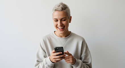 Fototapeta premium Nonbinary person laughing at phone on white background