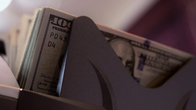 Currency counting machine. Counter machine with US money banknotes of 100 dollars. Slow motion. Close up view 