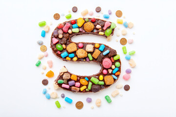 chocolate letter S surrounded by cookies and candies