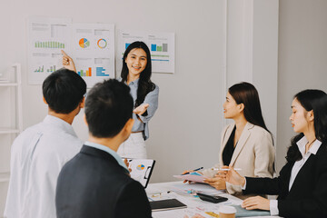 Team of financial advisory services. Asian advisor showing plan of investment to clients in the consultancy office..