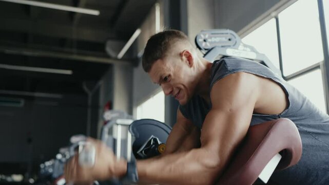 A determined man in a gym environment intensely working out on exercise equipment. This image captures the essence of fitness, strength, and dedication for a healthy lifestyle. Focused Man Working Out