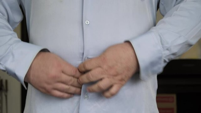 Overweight man's shirt buttons unbutton and come off on stomach due to big belly close-up, person suffering from obesity