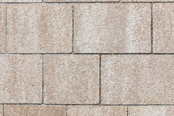 Sidewalk blocks in a rectangular pattern. Rough texture due to old age