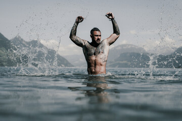 Sexy summer man. Muscular body. Hot summer. Man swimming in lake. Guy splash in water in summer...