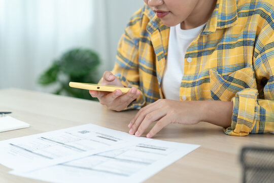 woman use phone scan barcode or QR codes to pay credit card bill after receiving document invoice. payment, receive, paying electricity, digital payments, technology, scanning, financial transactions - Powered by Adobe