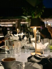 Candlelit outdoor dinner table with glassware.