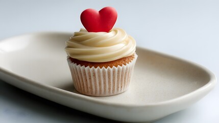Delicious cupcake topped with swirled cream and a red heart, perfect for a sweet treat or special occasion.