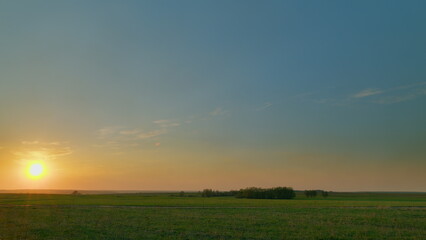 A Serene and Beautiful Sunset and its Glow Over the Lush and Vibrant Green Fields of Rich Farmland