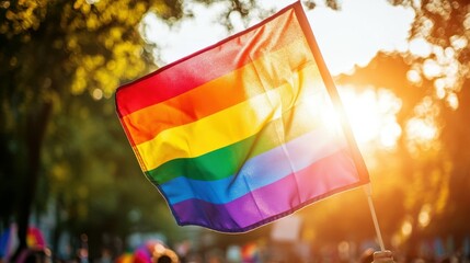 LGBTQ+ pride flag waving at a parade, celebrating diversity and unity under the sunlight. Free copy space for text.