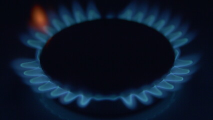 The illuminated flames from a gas burner create a mesmerizing ambiance against a dark background