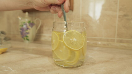 Enjoying Refreshing Lemon Water Served in a Beautiful Glass Jar Perfect for Summer Days