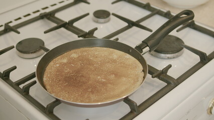 Enjoying the delicious and appetizing pancake being cooked on the stove for breakfast
