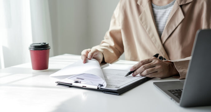 Female doctor holding a medicine bottle is checking the quality of medicine for any side effects the patient or not and recording patient information at the hospital. medical and health care concept