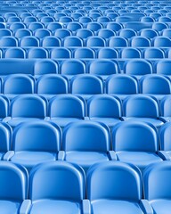 Obraz premium A repeating pattern of blue stadium seats, arranged in rows, creating a symmetrical and minimalist design