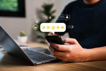 Customer giving five star rating review on smartphone with laptop on wooden table, positive feedback evaluation, online service satisfaction, business reputation management, digital marketing concept