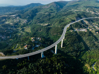 Wide aerial of A4 highway viaduct sweeping across a green valley in Portugal