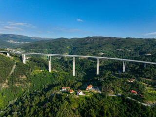 Highway overpass viewed from above, cutting through lush residential countryside in Portugal