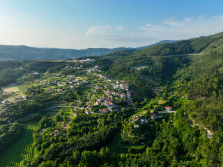 Panoramic aerial of Gião village embraced by trees and cultivated fields