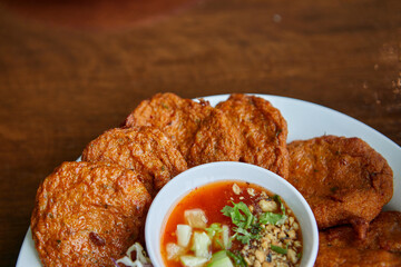  Fried fish-paste balls or deep fried fish cake with sweet sauce on plate
